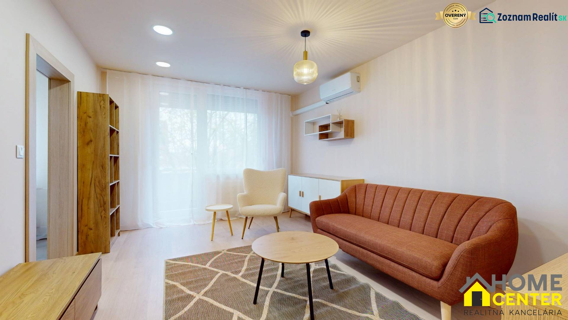 Living room with a sofa, an armchair, and a wooden decor floor in a three-room apartment.