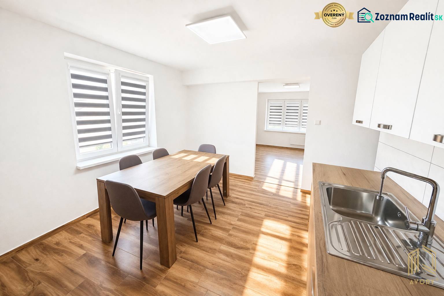 Dining room in a two-room apartment with a wooden decor floor and sunlight illumination.