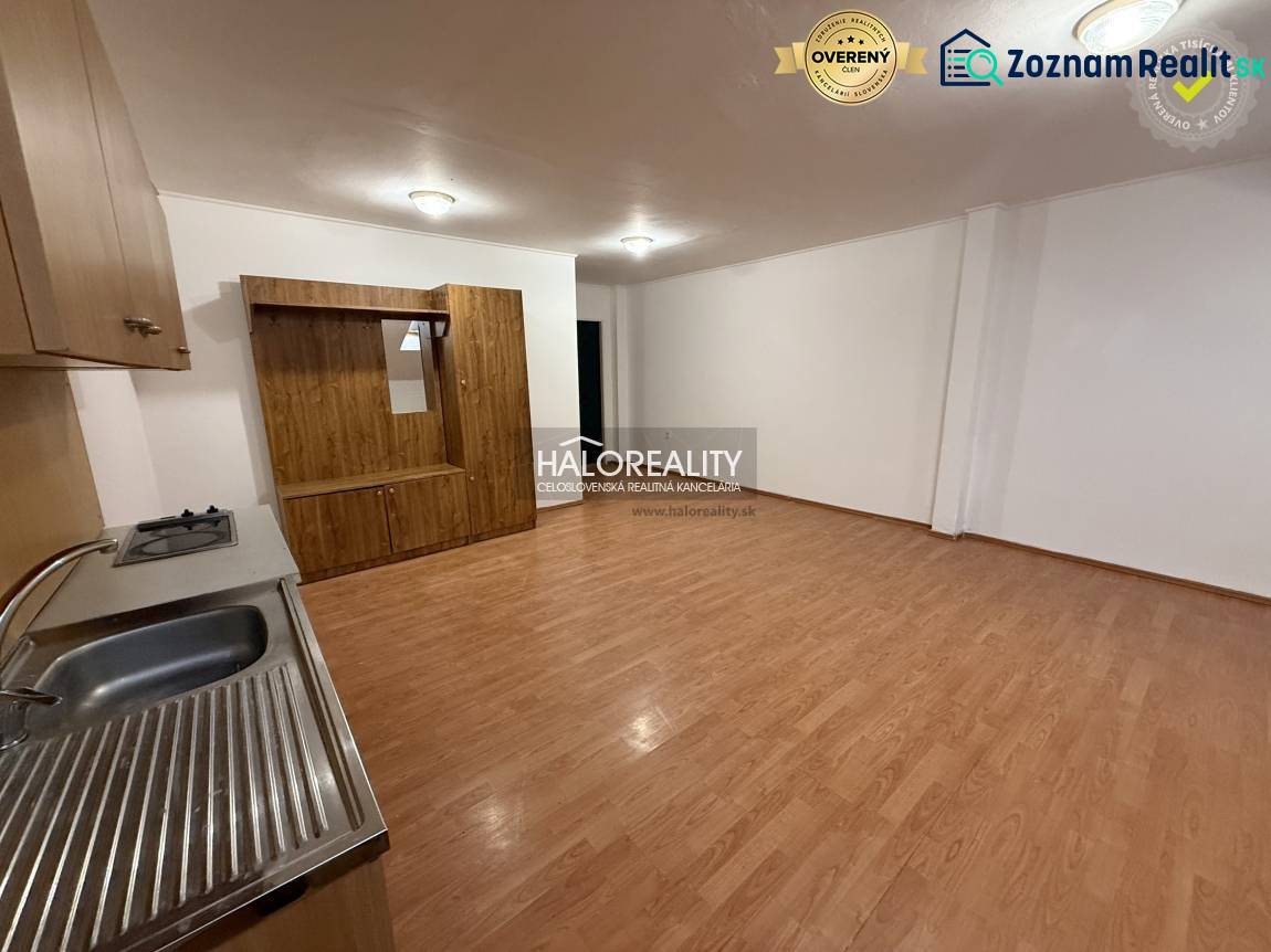 Studio apartment with a kitchenette and a wooden decor floor.