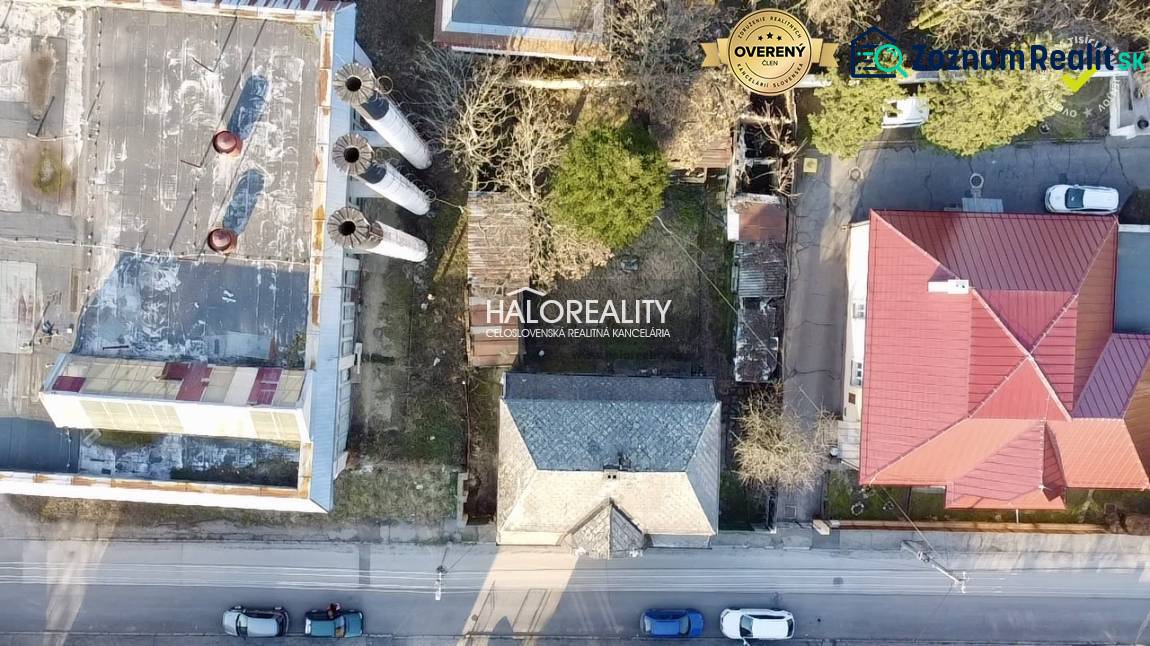 Aerial view of a family house in Rimavská Sobota next to an industrial building with four chimneys.
