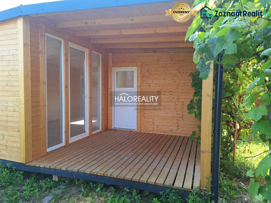 A wooden terrace by the house in the Gardens in Bojnice, surrounded by vines.