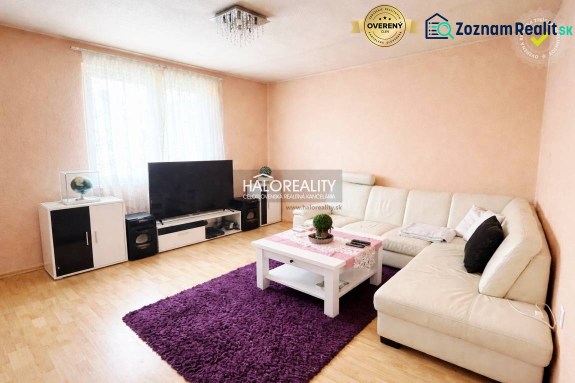 A living room in a family house with a sofa, a wooden decor floor, and a television.