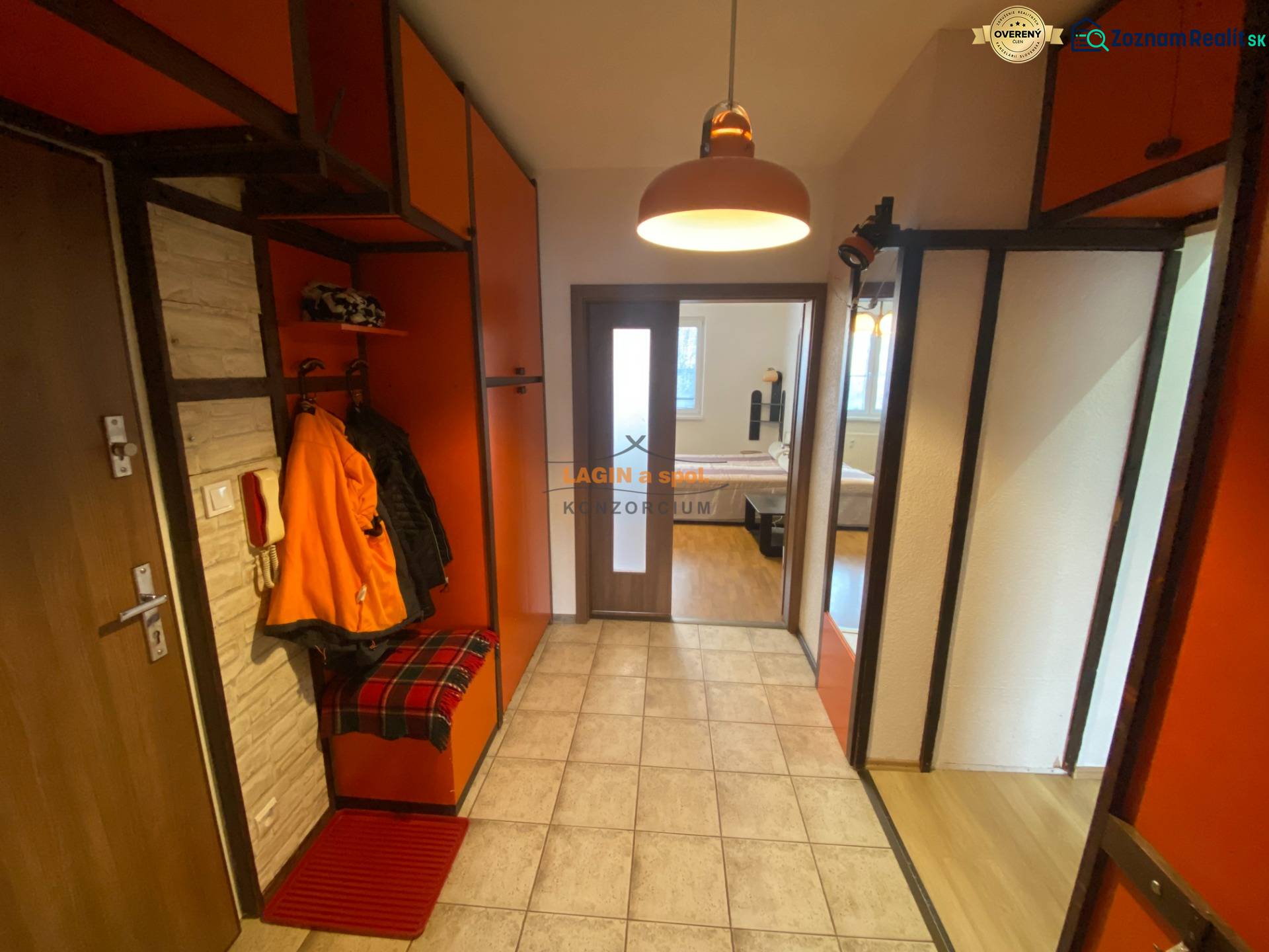 The entrance hall of a 3-room apartment with orange cabinets and tiles.