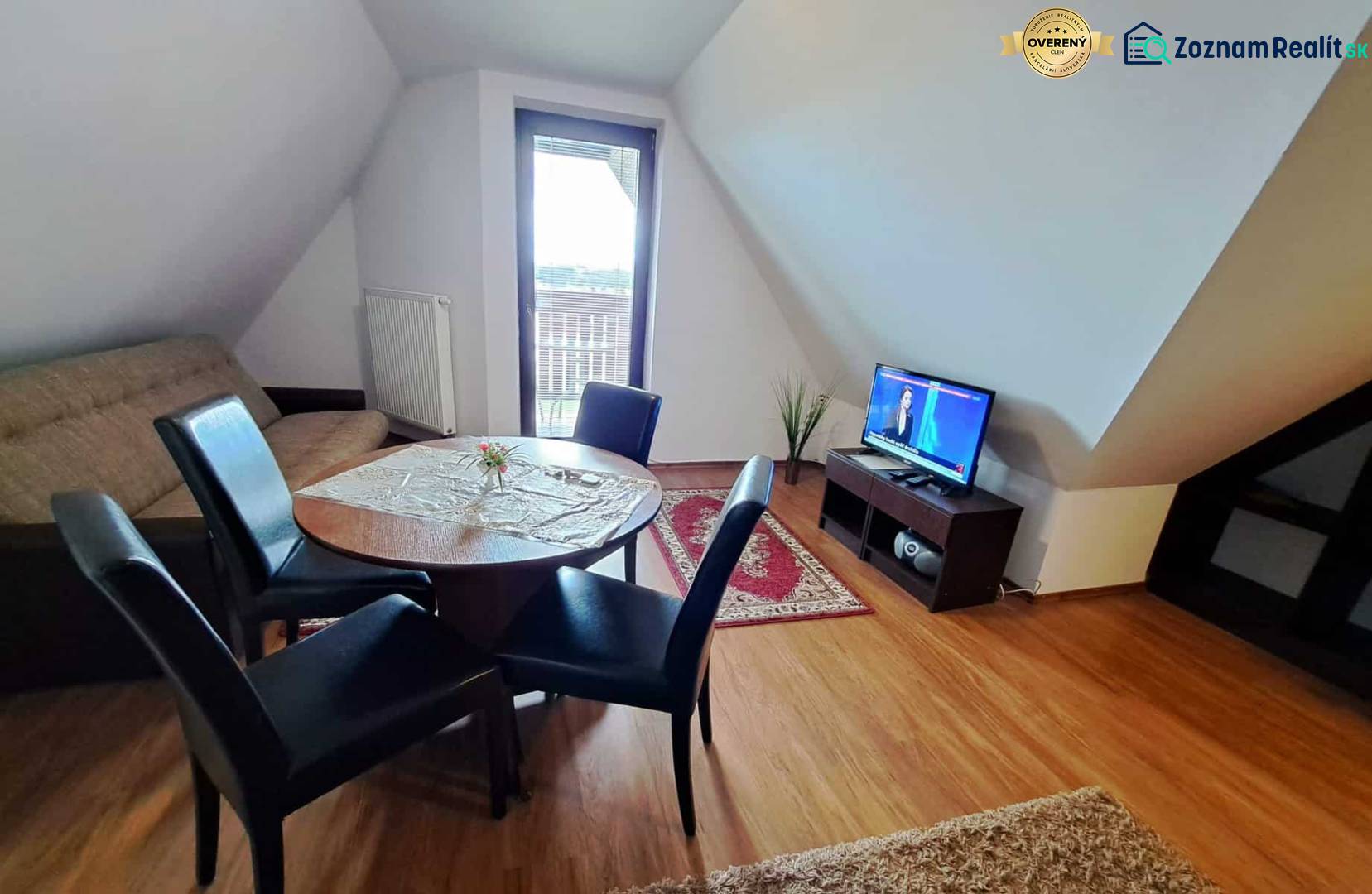 A living room in a three-room apartment with a wooden decor floor and a dining table.