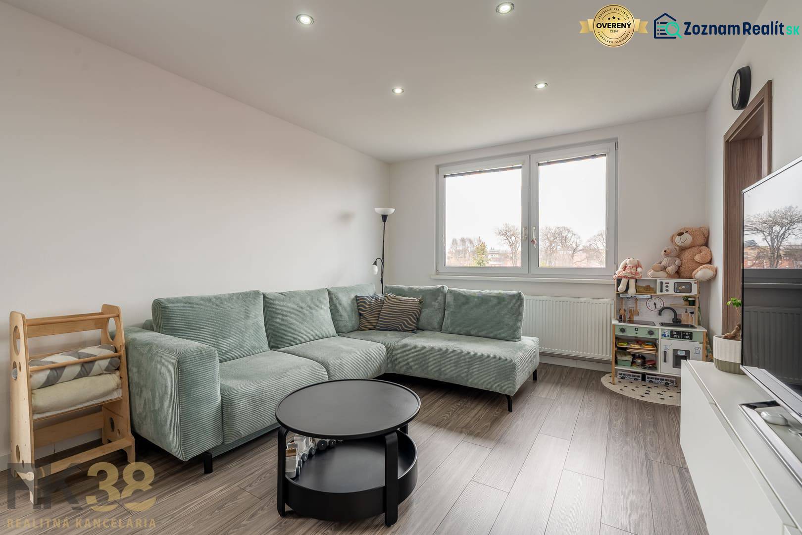 Living room with a corner sofa and a wooden decor floor in a 4-room apartment.