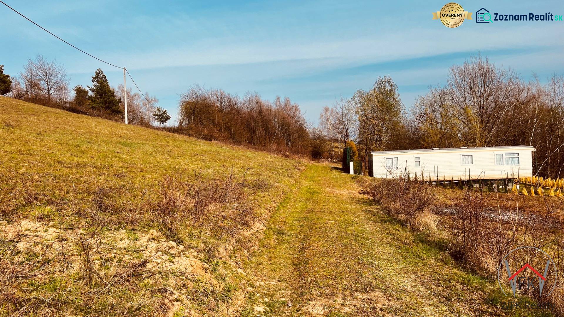 A cottage on a slope surrounded by greenery and trees in the Recreational Lands of Nova Kelc.