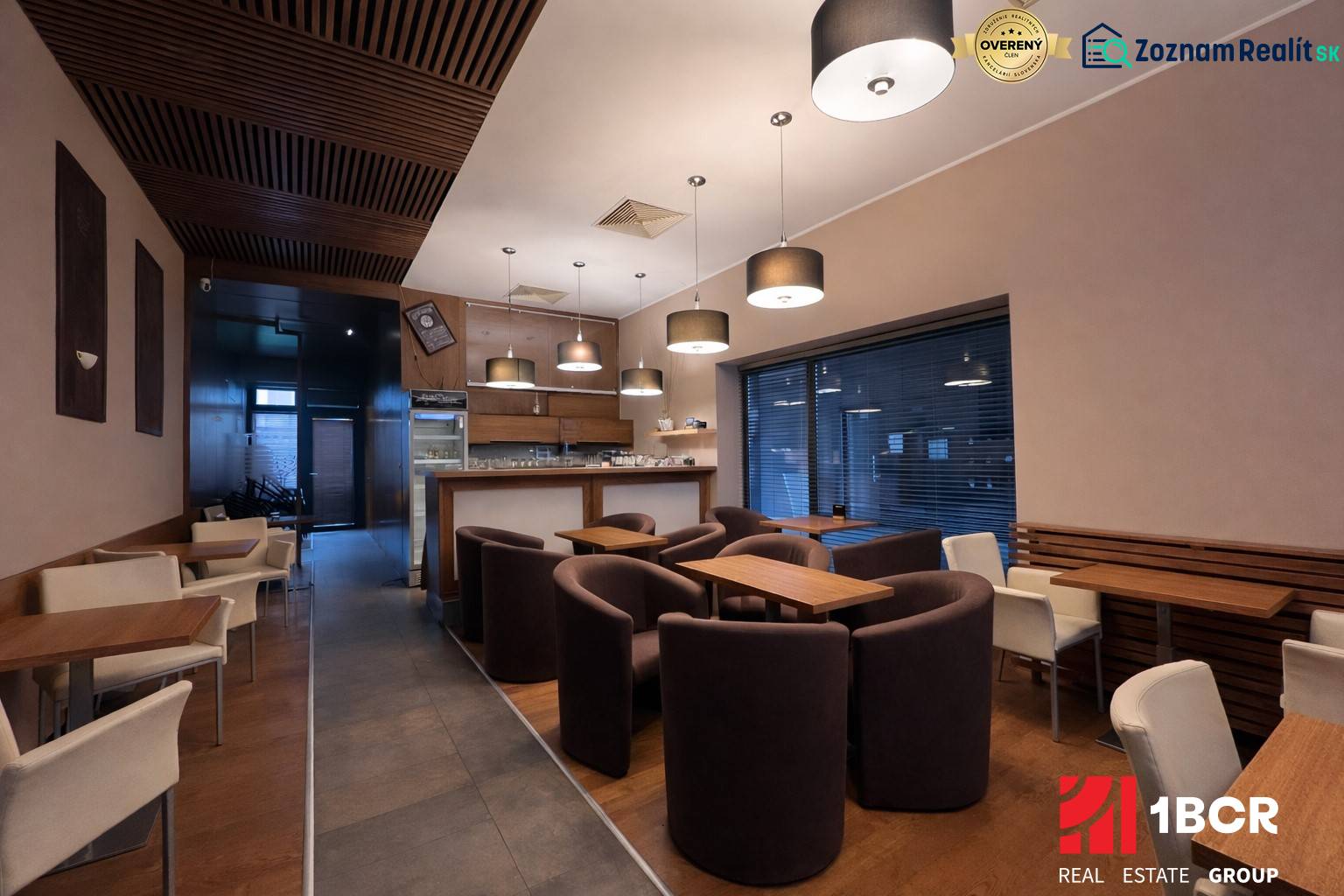 Interior of a commercial space with comfortable armchairs, wooden decor, and modern lighting.