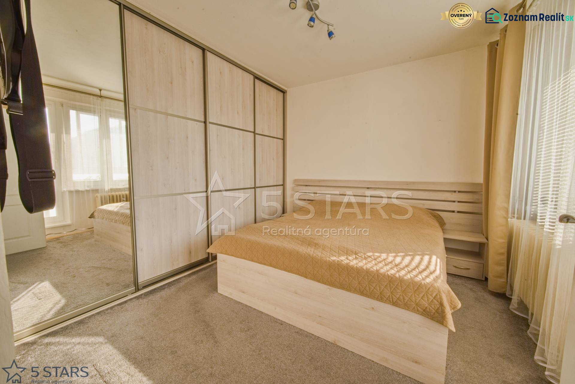 A bedroom with a large built-in wardrobe and a bed in a 3-room apartment.
