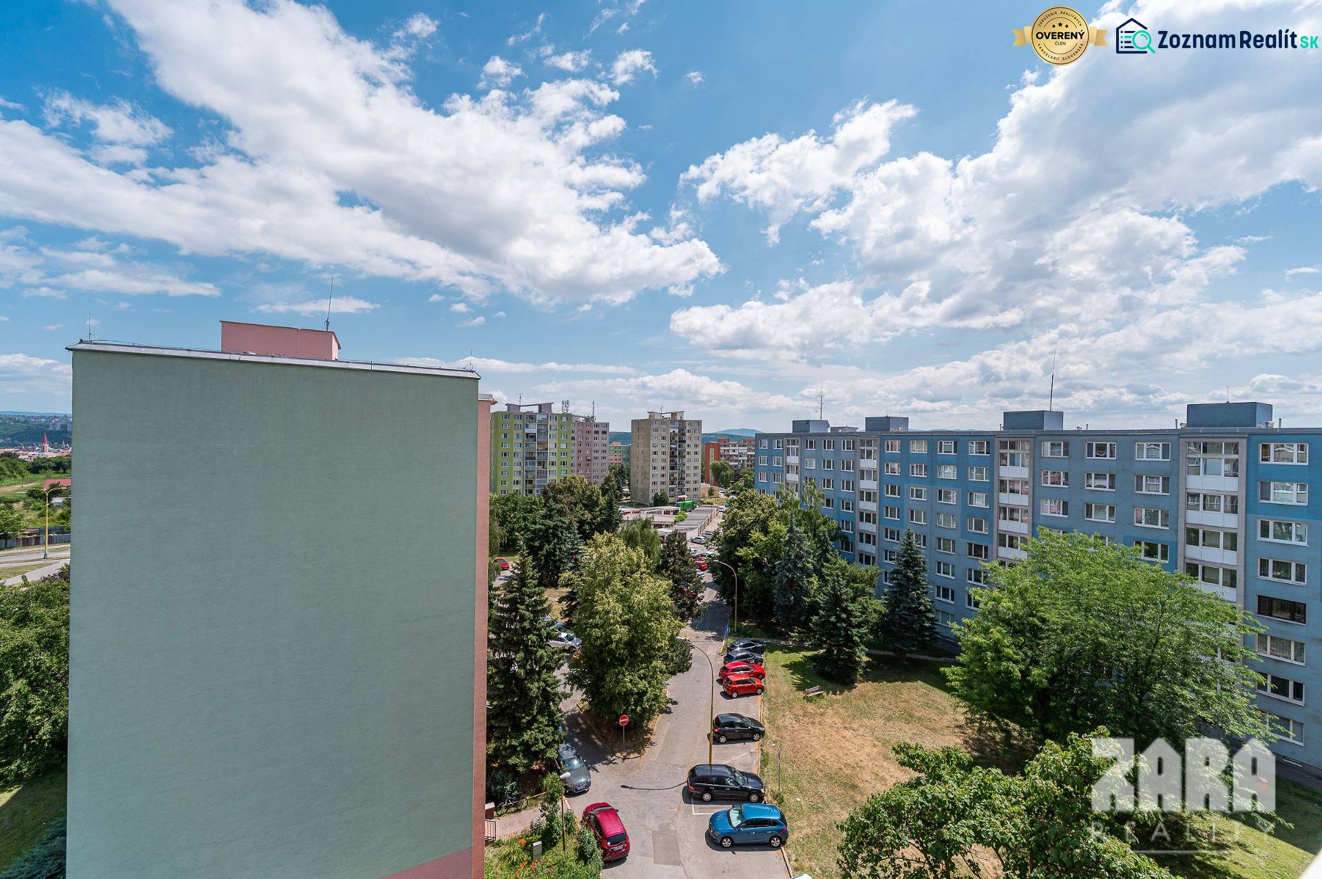 Apartment buildings in the Košice - Západ district, Pražská Street, surrounded by greenery and parked cars.