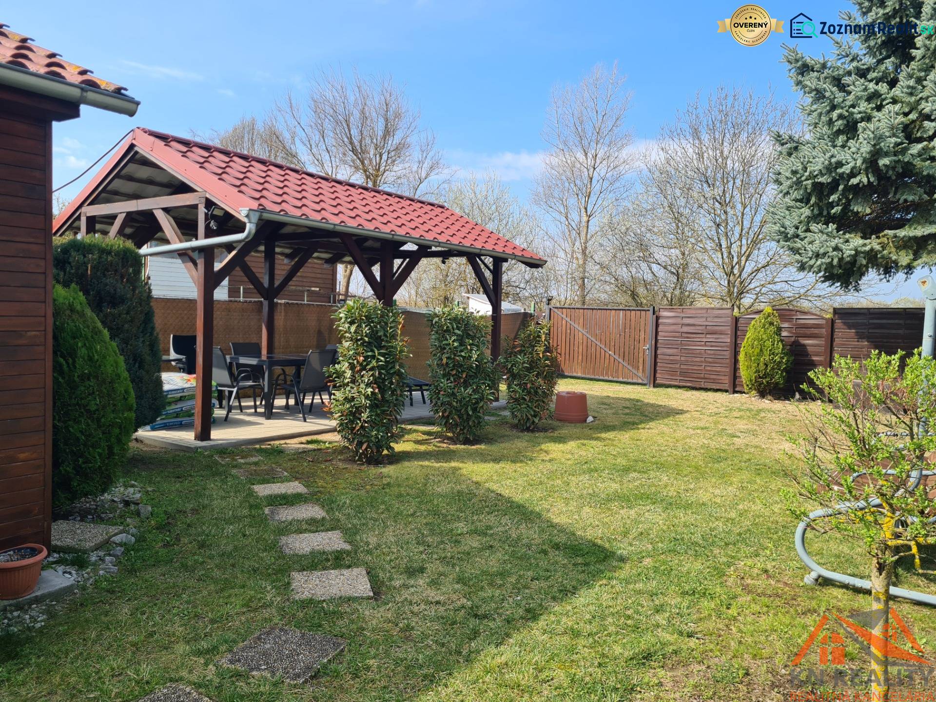 A cottage in Štúrovo with a gazebo, lawn, and trees; a peaceful garden for relaxation.
