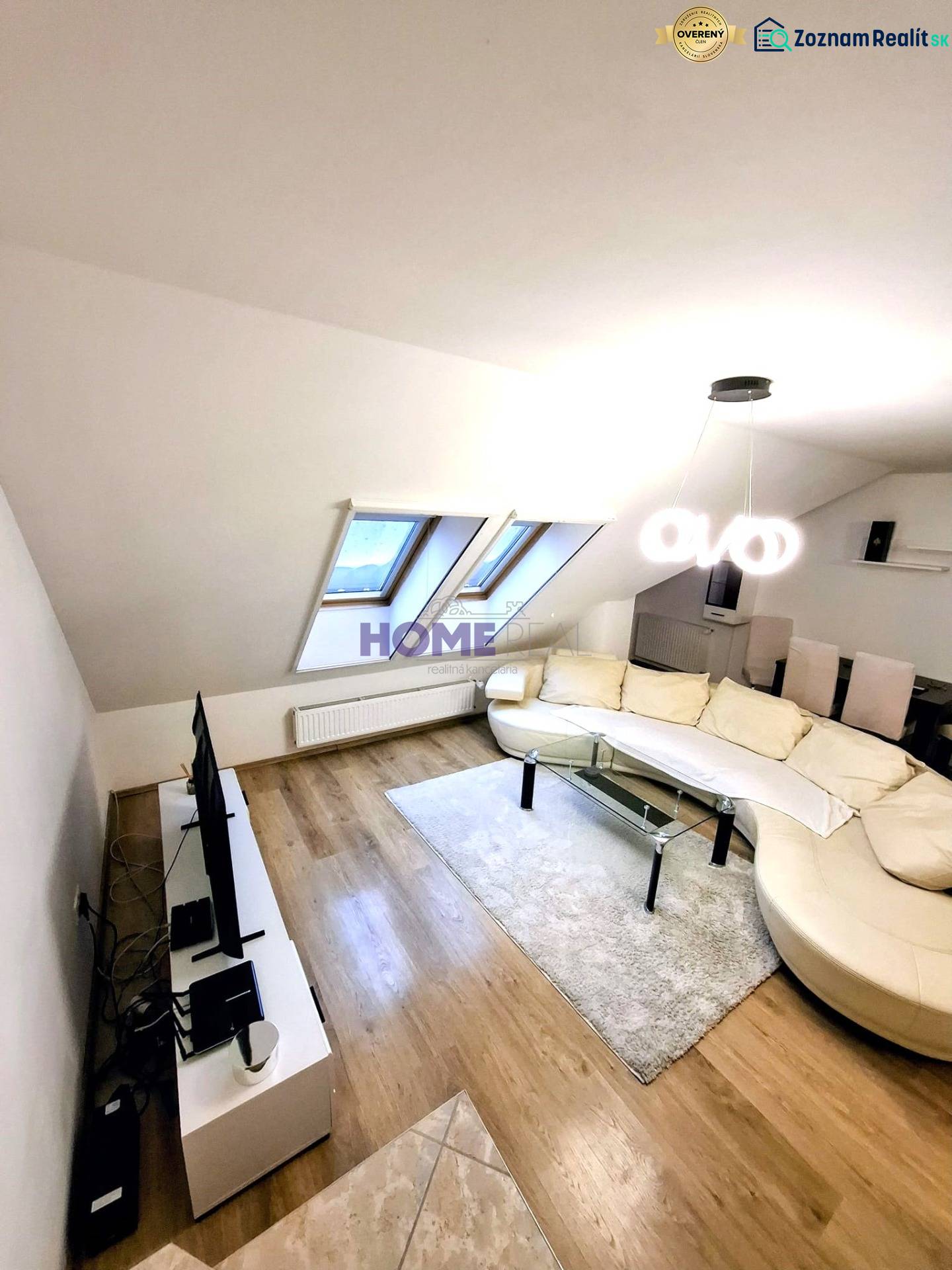 Living room in a three-room apartment with a wooden decor floor and a comfortable couch.