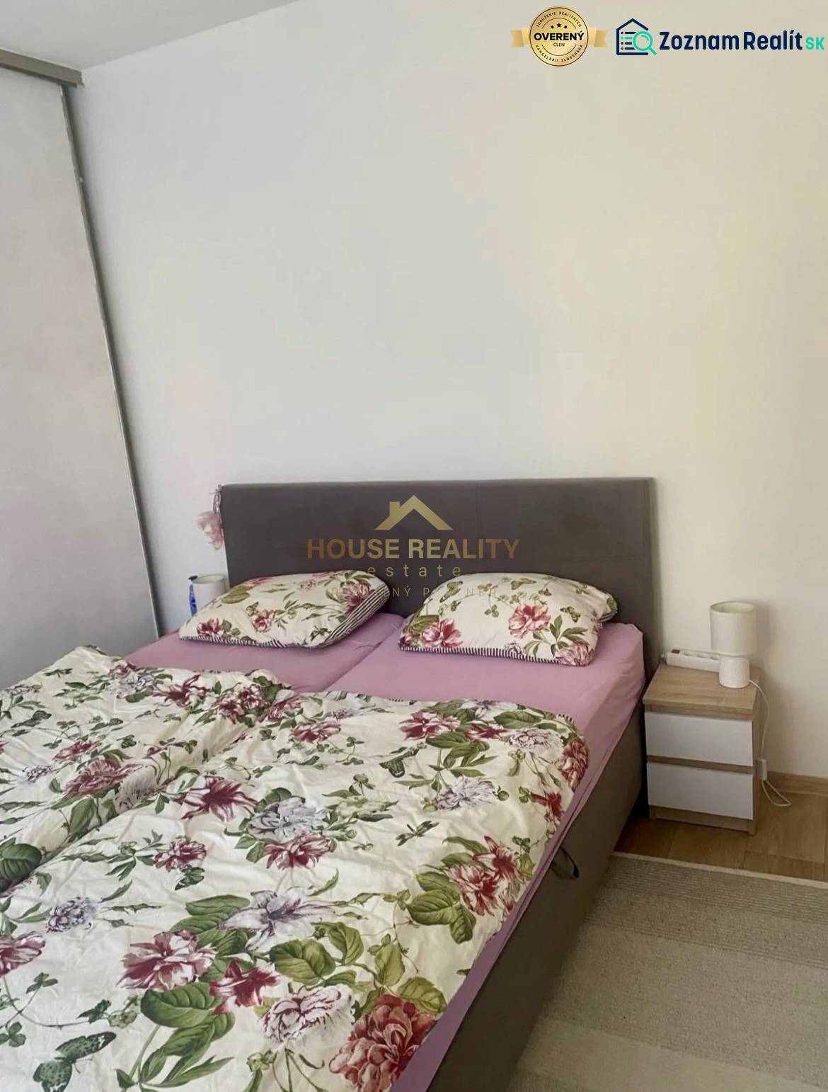 Bedroom in a 3-room apartment with a bed and floral bedding on the bed.