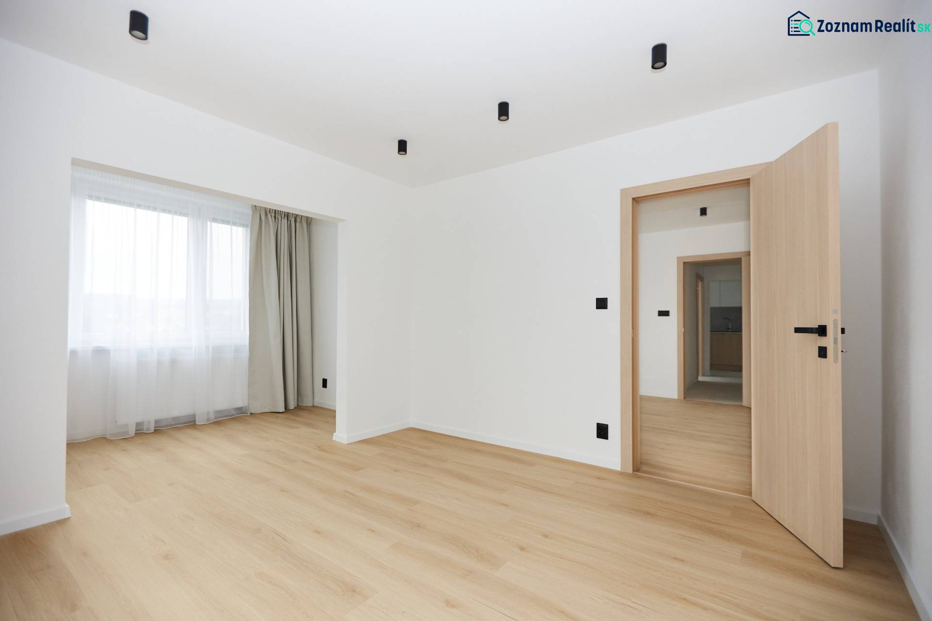 A room with a wooden floor decor and curtains in a 3-room apartment.
