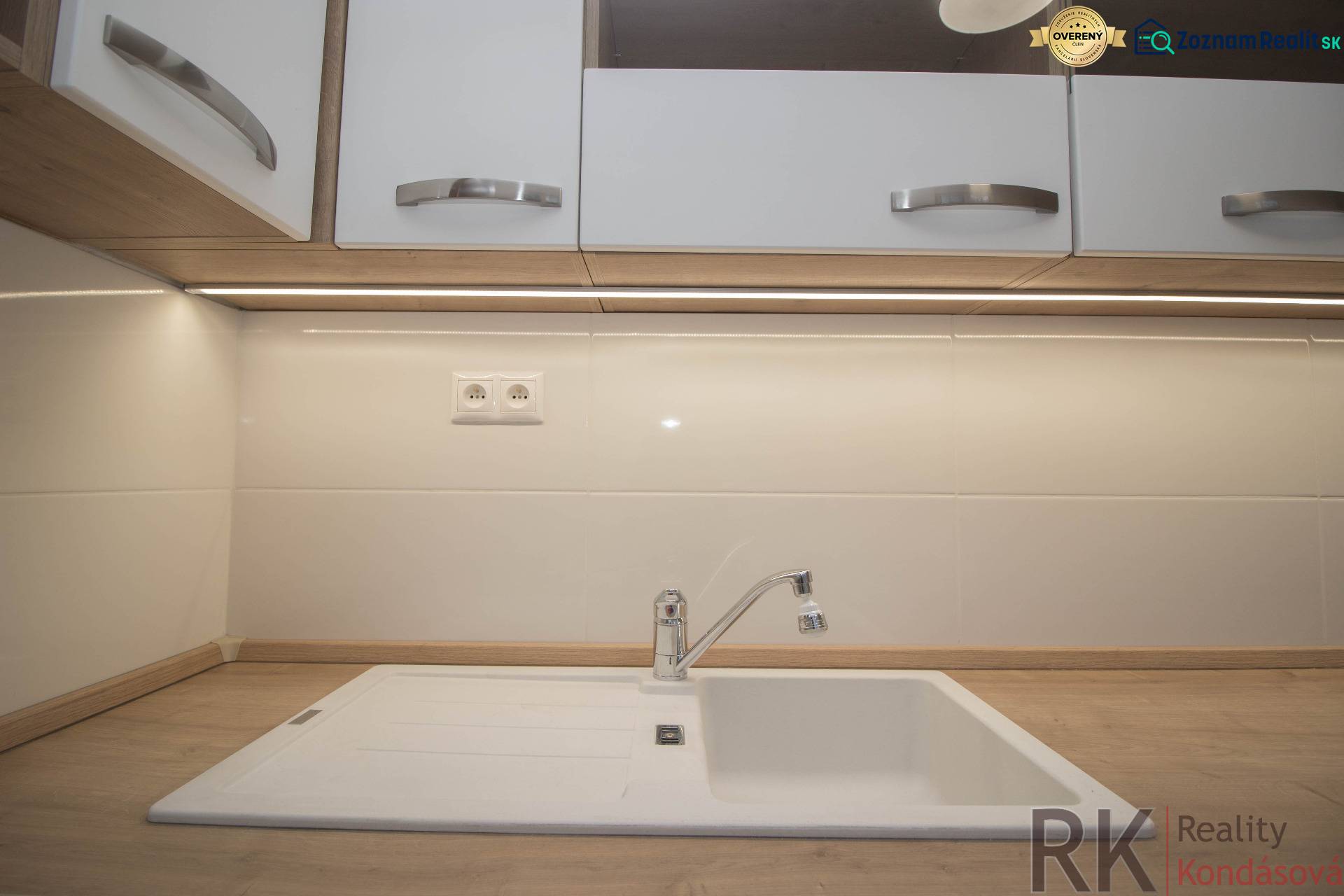 A kitchen countertop with a wood decor and a white sink in a 2-room apartment.