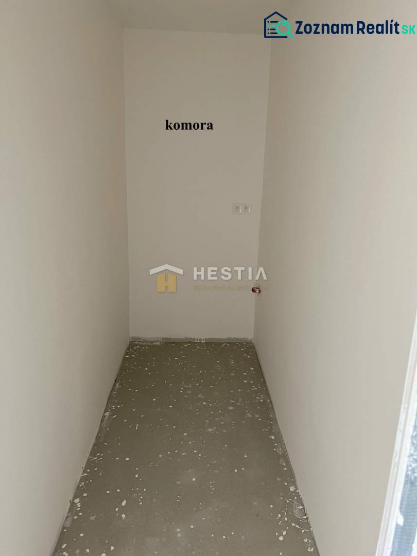 A small pantry room in a 2-room apartment with white walls and a concrete floor.