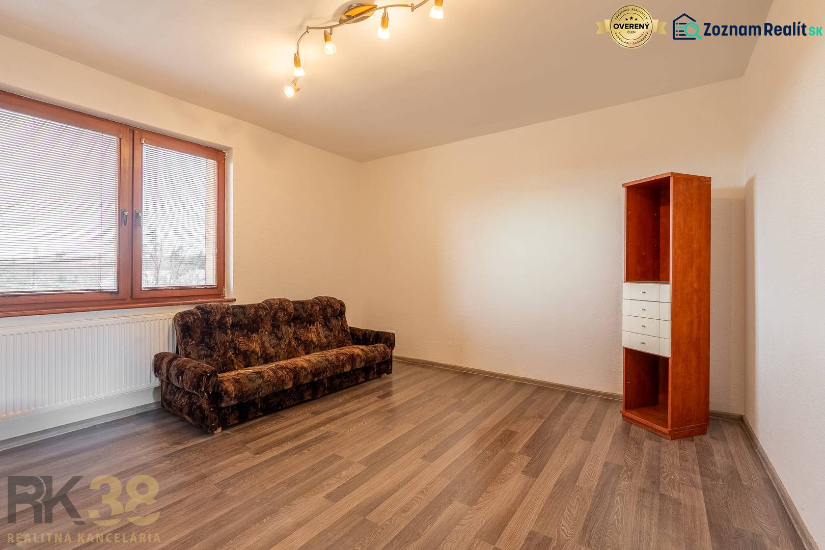 A room in a 5 or more room apartment with a sofa, a shelf, and a floor with a wooden decor.
