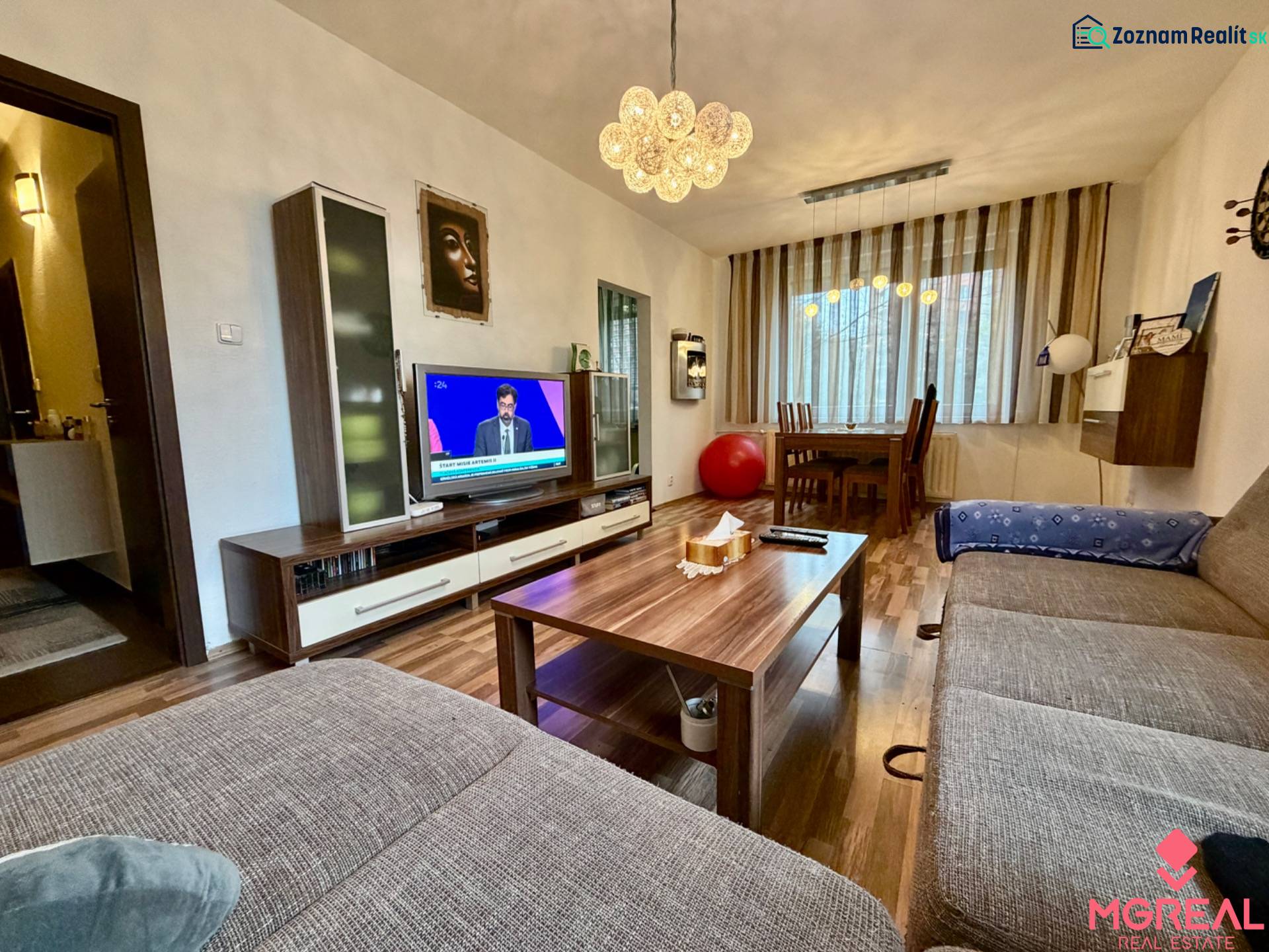 Living room in a three-room apartment with a wooden decor floor and a comfortable sofa.