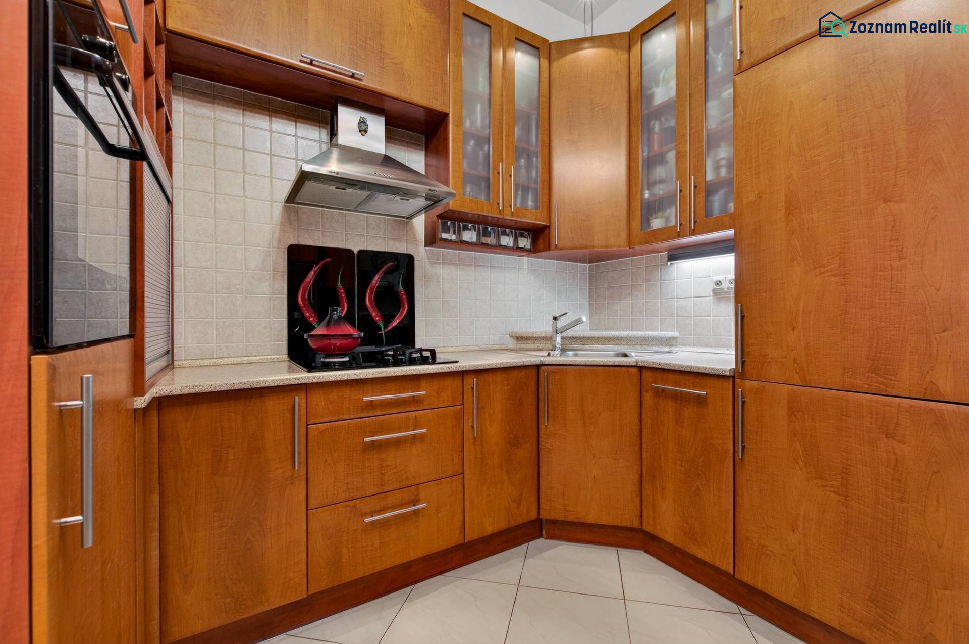 A kitchen in a 3-room apartment with wooden furniture and built-in appliances.
