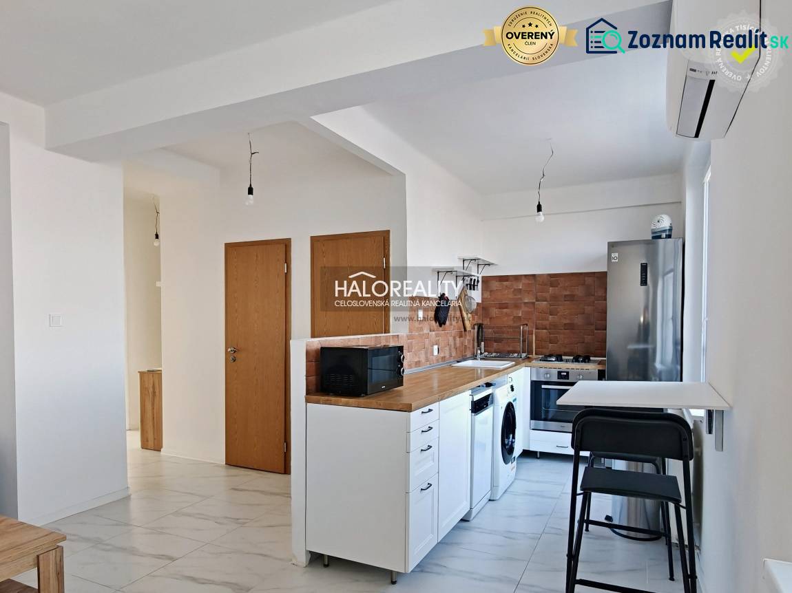 A kitchen in a 3-room apartment with white cabinets, appliances, and wooden decor.
