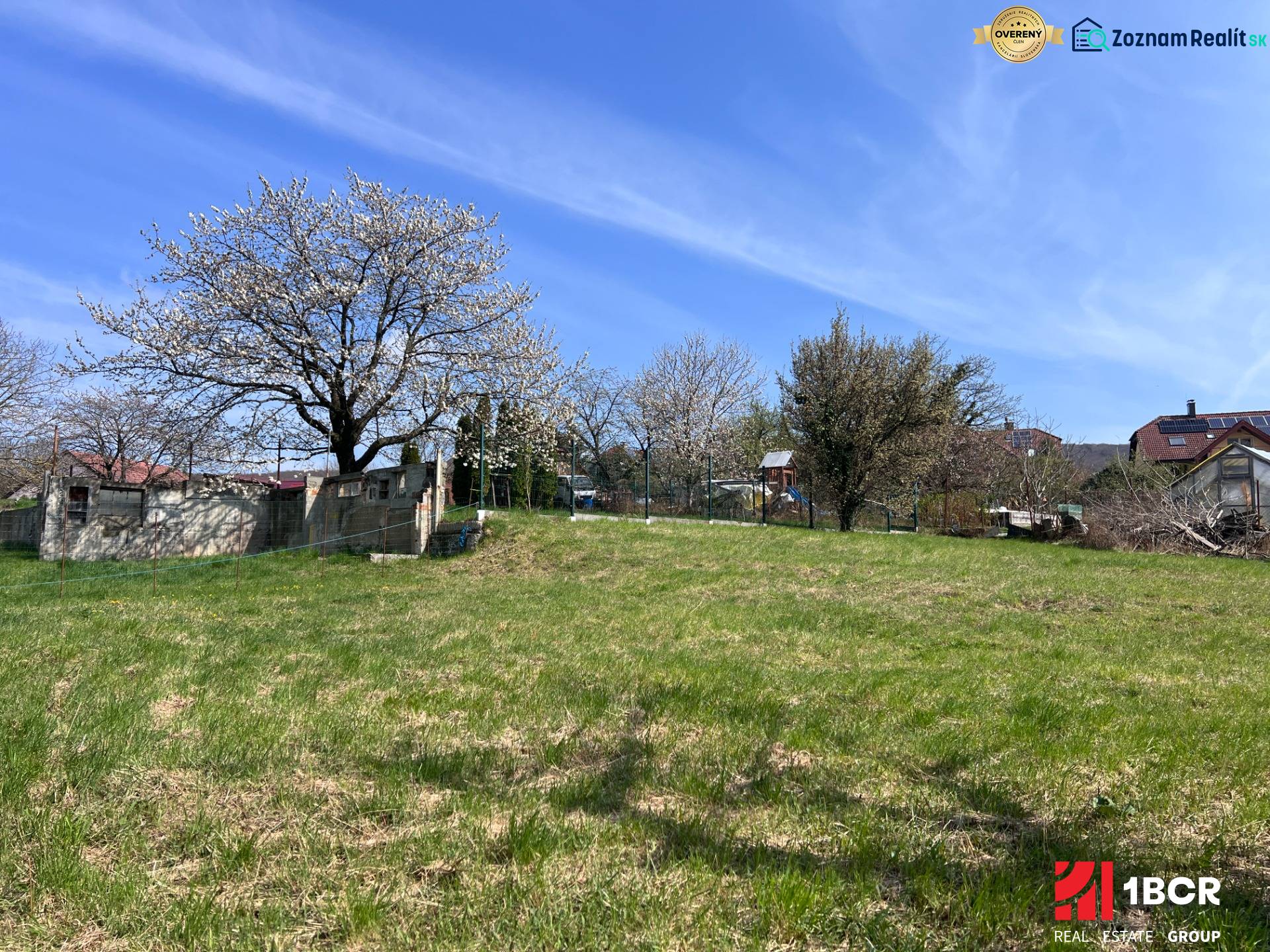 Blooming trees and a grassy area on a residential plot in Marianka on Budovateľská Street.