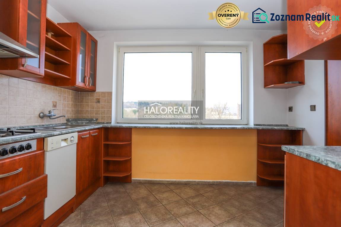 A kitchen in a family house with a kitchen unit and a large window, tiled floor.