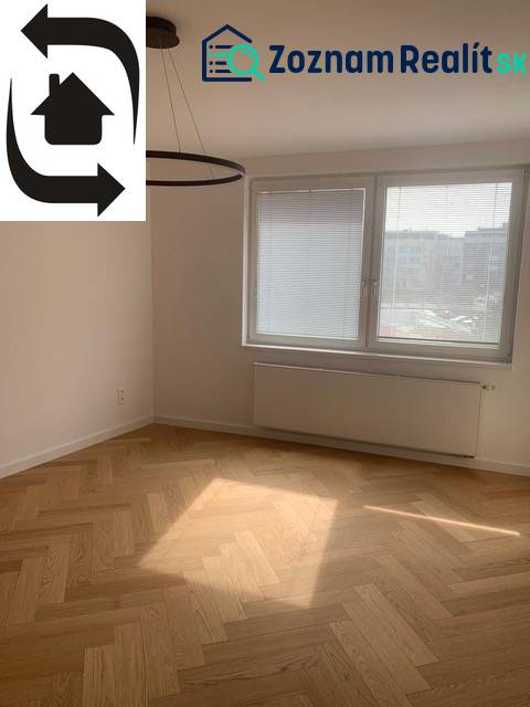A bright room with a wood-decor floor in a two-room apartment, large window.