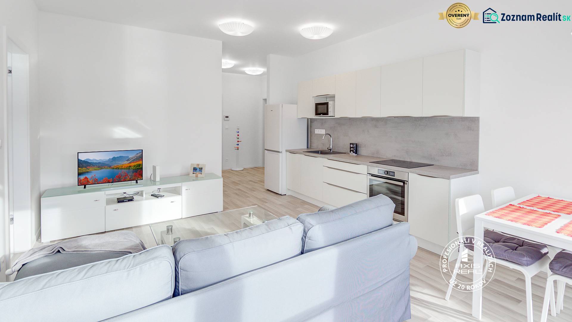 Living room in a two-room apartment with a kitchen, sofa, and TV.