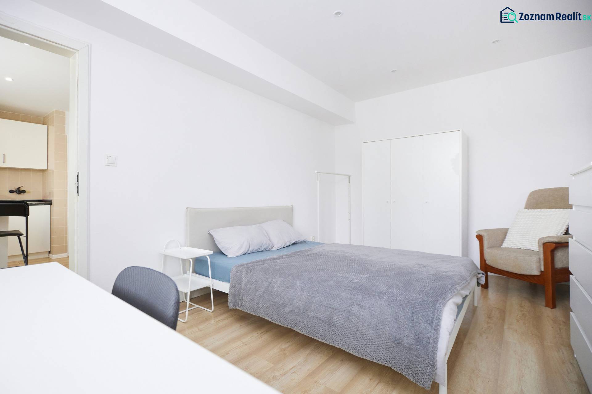 Bedroom of a two-room apartment with a bed, wardrobe, and floor with a wooden decor.