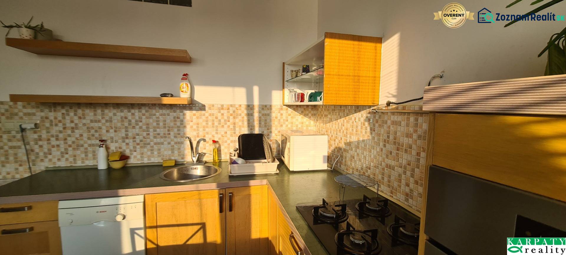 A kitchen in a 3-room apartment with wooden cabinets and mosaic tiles.