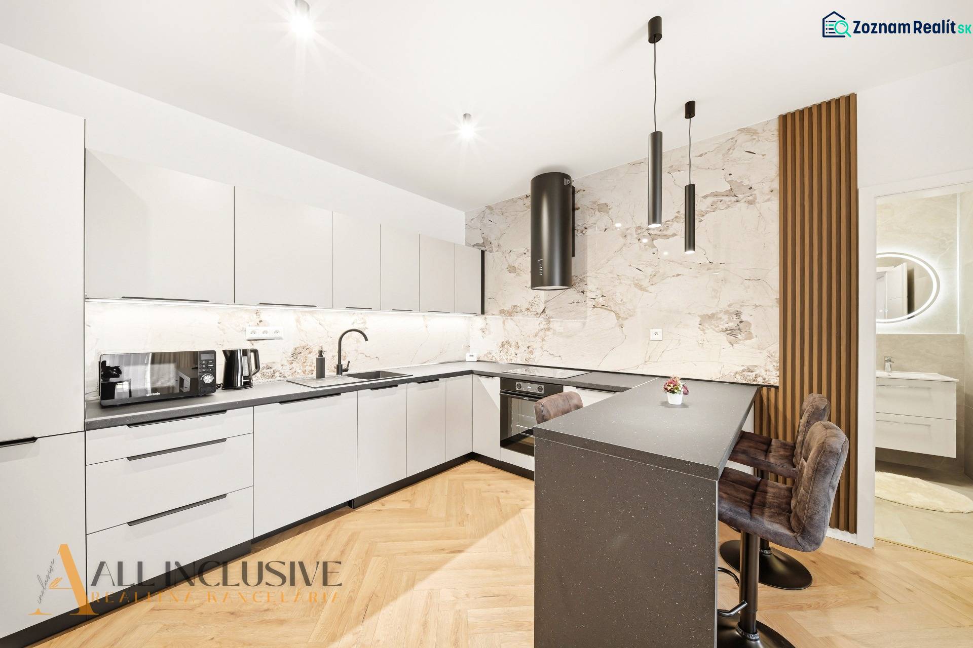 A kitchen with white cabinets, an island, and wood-patterned flooring in a 4-room apartment.