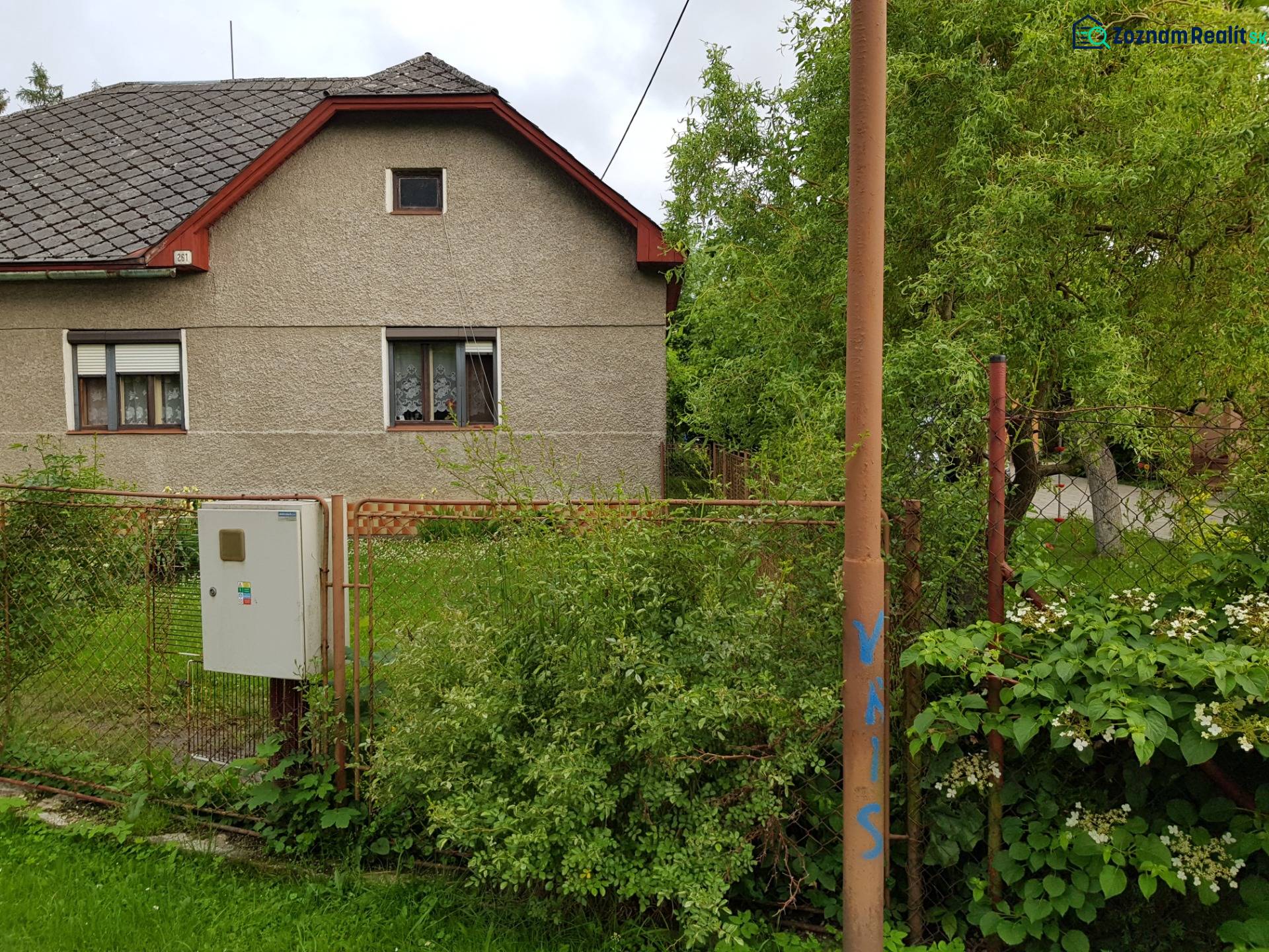 A family house in Blatnica on Blatnica Street surrounded by greenery and a fence.