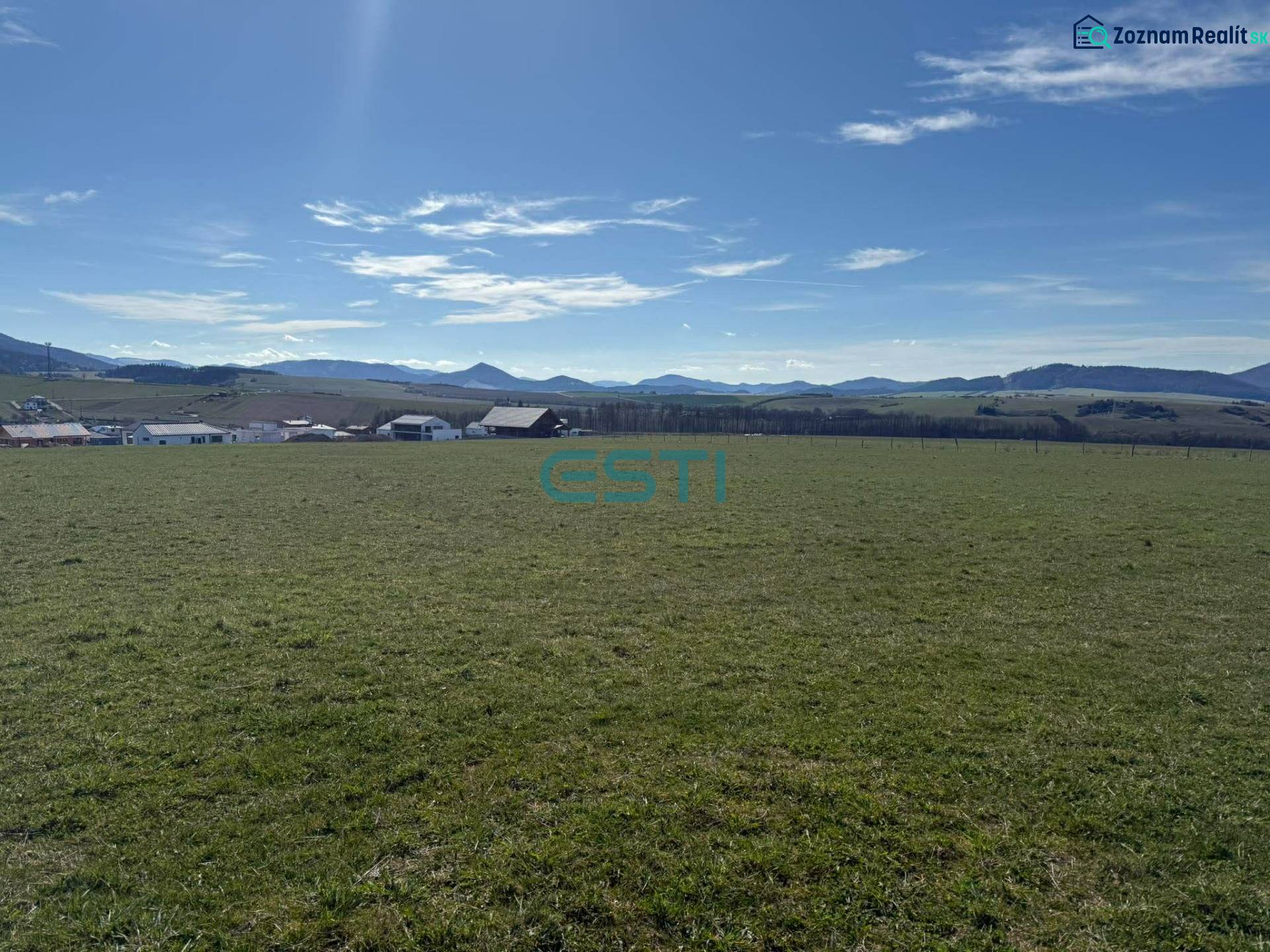 Plots - living in Stránske on Borie Street. A vast green meadow with a mountain backdrop.