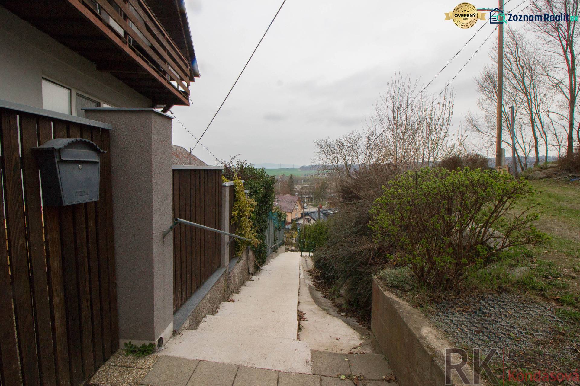 The access path to the family house in Kostoľany nad Hornádom, enclosed by a wooden fence.