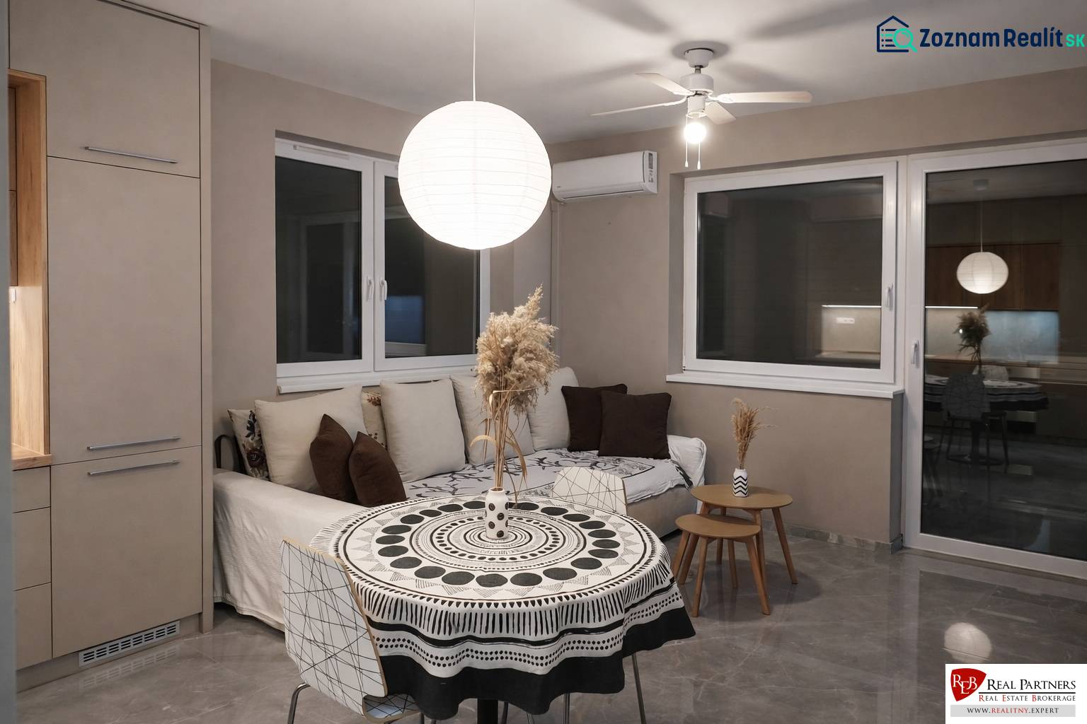 Living room with a sofa, round table, and decorative light fixture in a 2-room apartment.