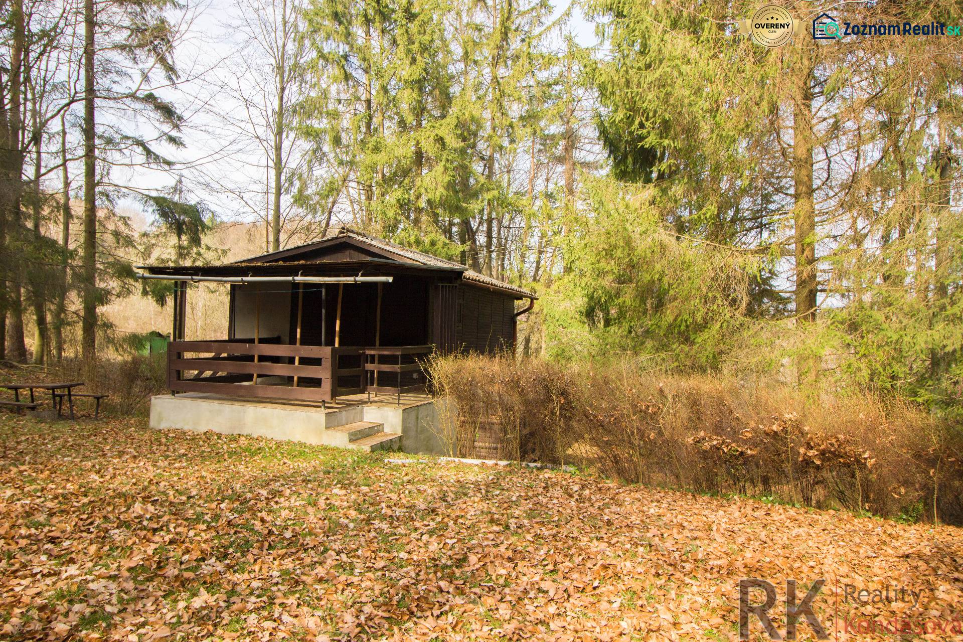 A cottage surrounded by forest on recreational land in Holčíkovce during autumn.