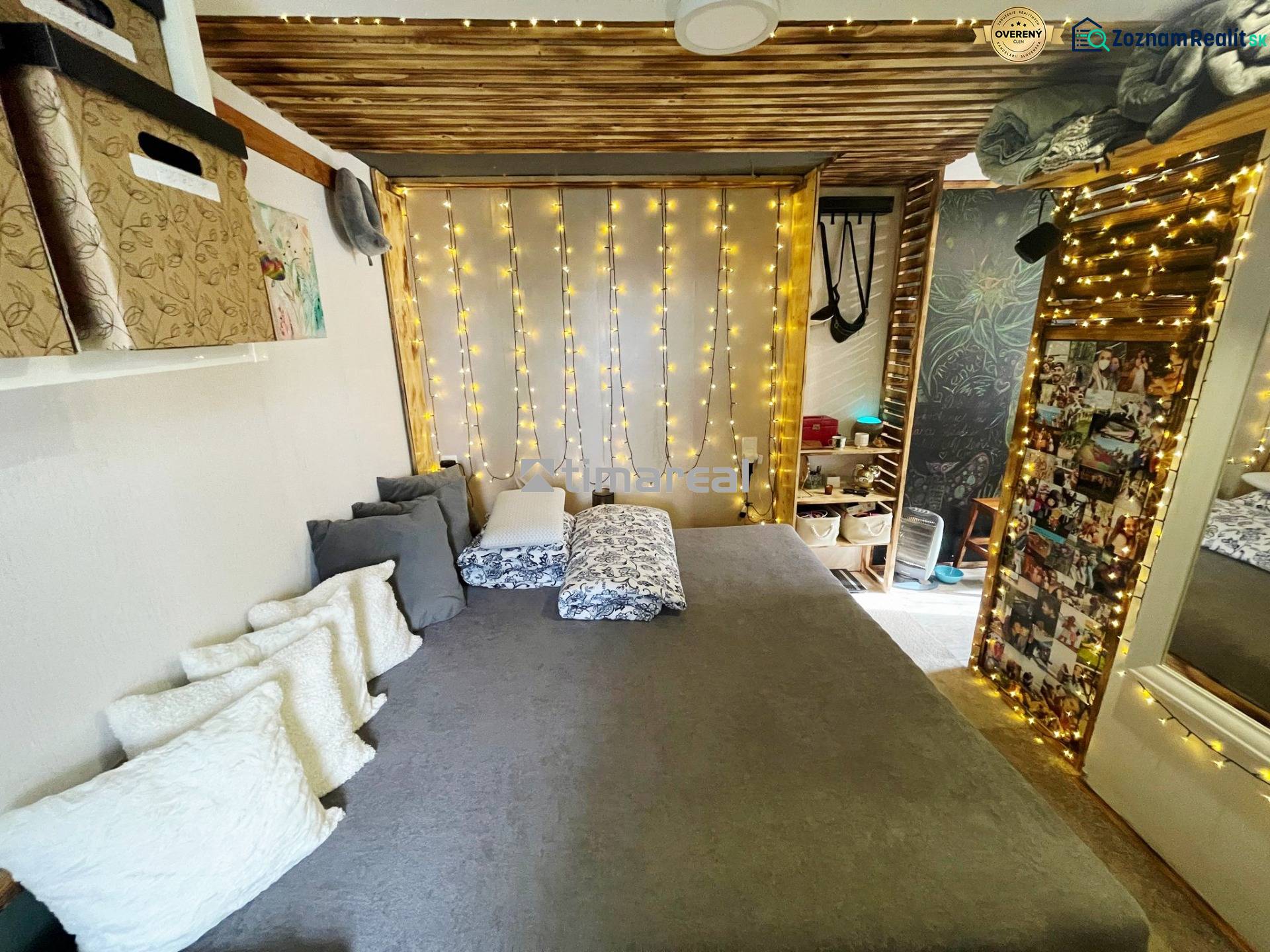 Interior of a family house with a bed, pillows, and light decoration.