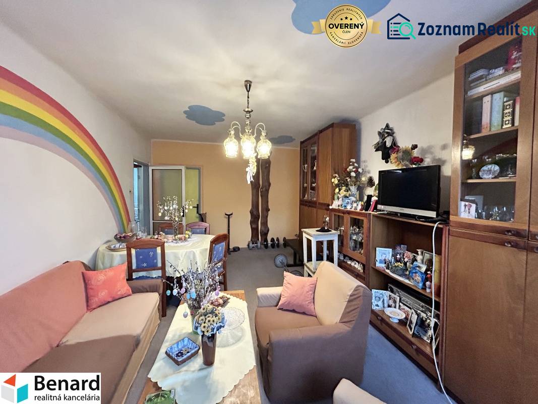 Living room in a 3-room apartment with sofas, furniture, and a painted rainbow on the wall.