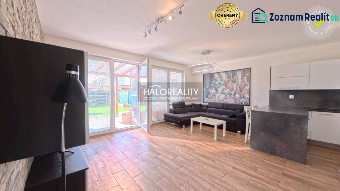 2-room apartment with wood-patterned flooring, a sofa, and a kitchenette.