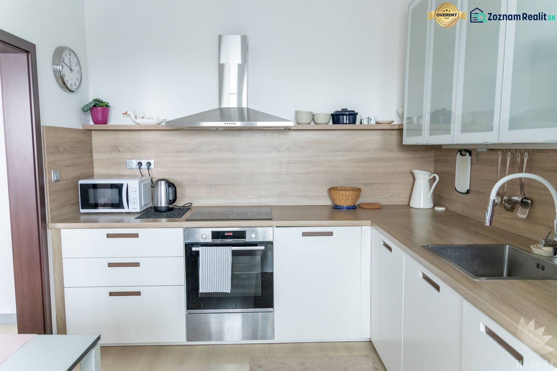 A kitchen with built-in appliances in a 4-room apartment, floor with wood decor, light-colored cabinetry.