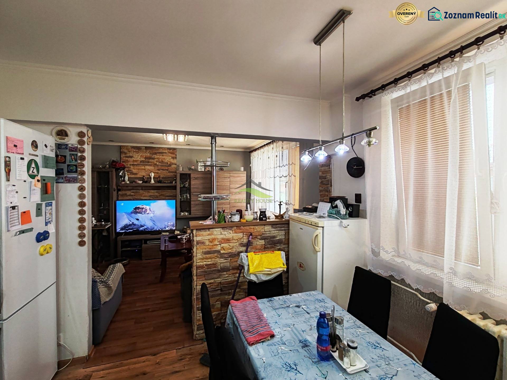 Dining room in a 4-room apartment with a wood-patterned floor and a television.