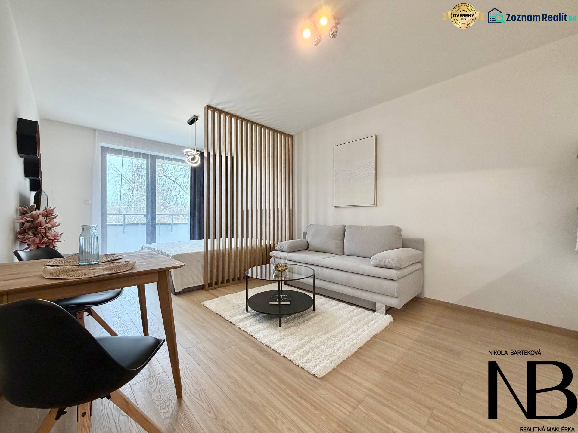 Living room with a sofa and a dining table, wooden decor flooring, studio apartment.
