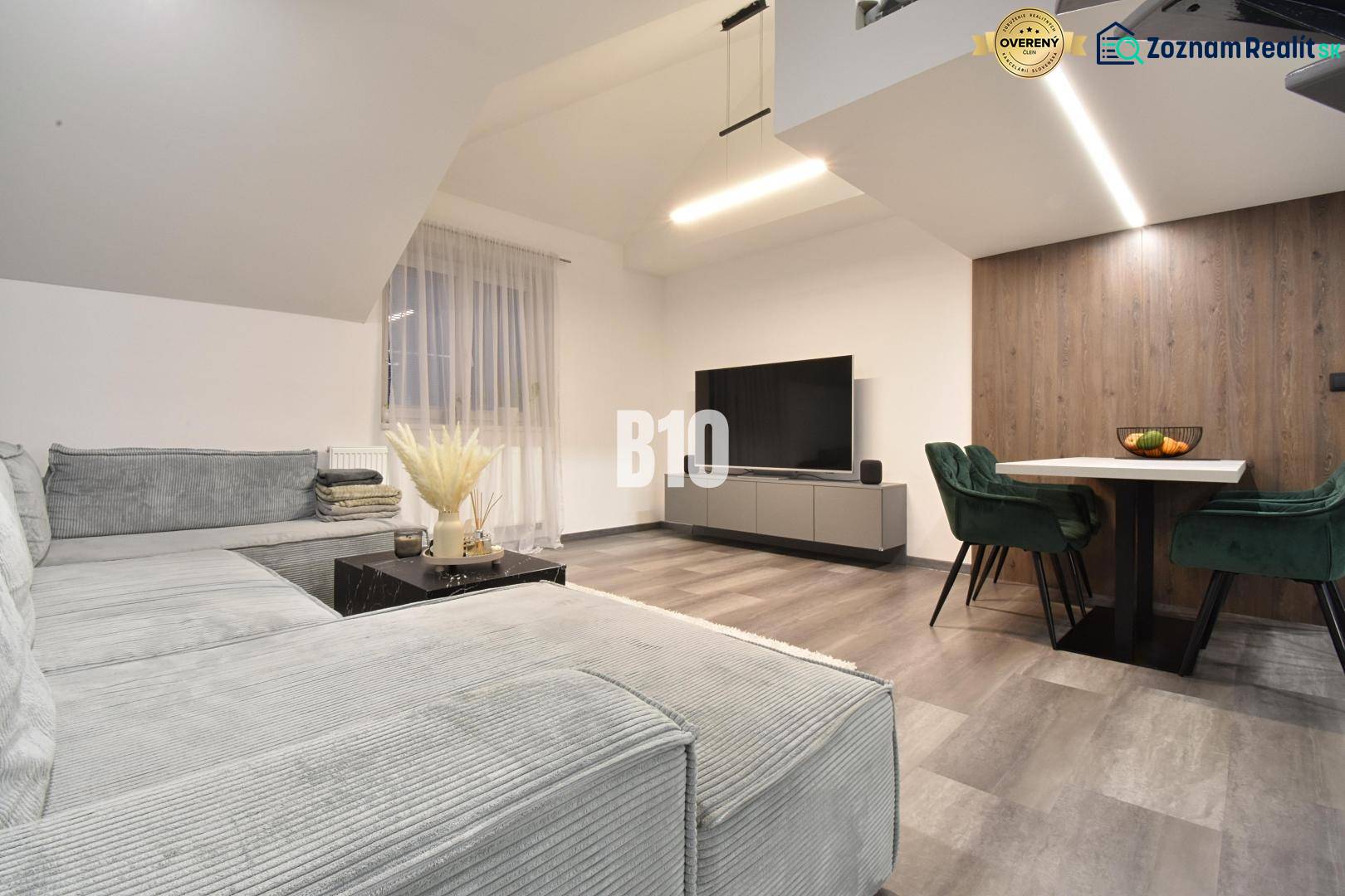 Living room in a 4-room apartment with a sofa, television, and wooden decor flooring.