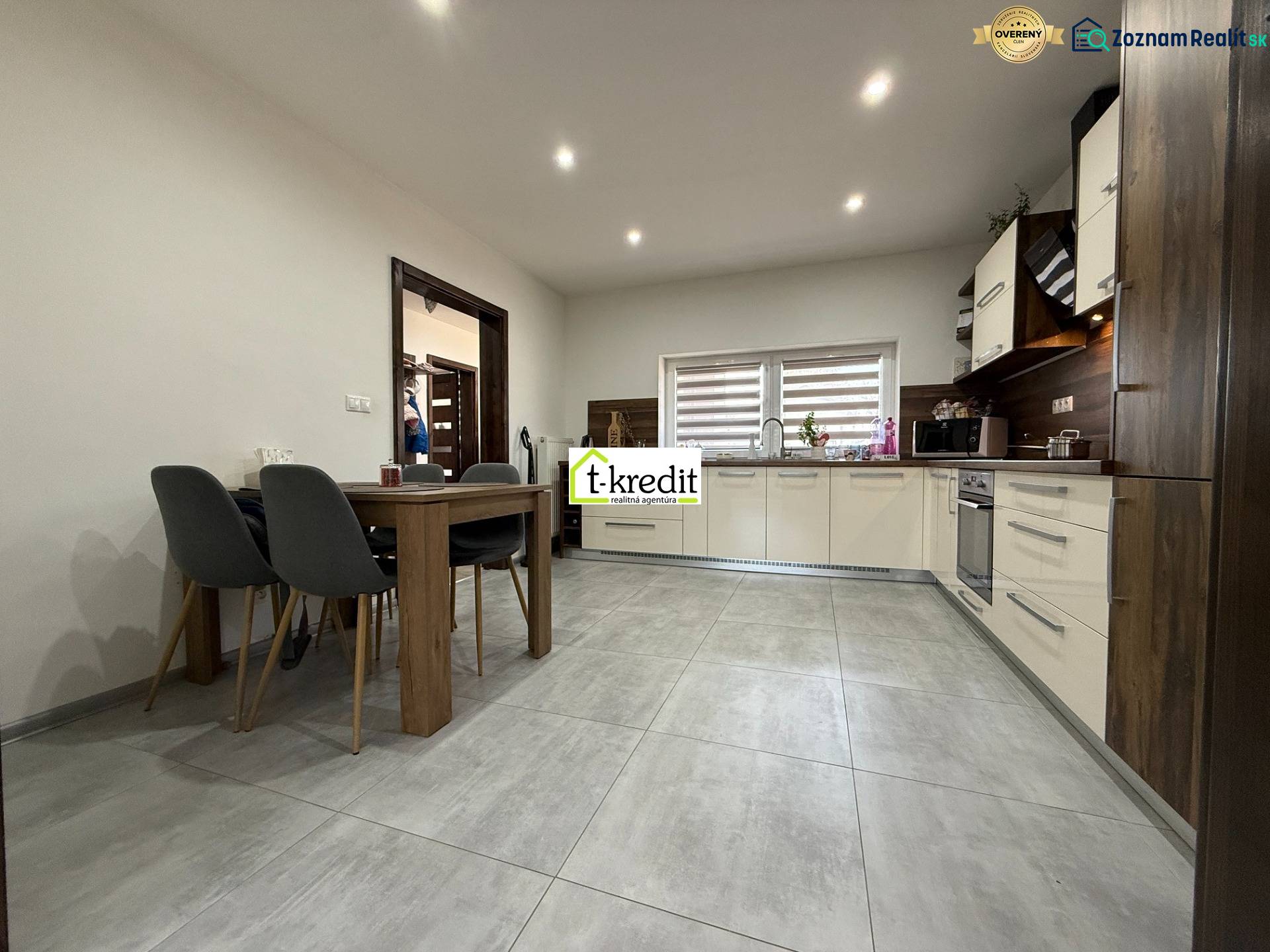 A kitchen in light colors with built-in appliances and a dining table in a family house.