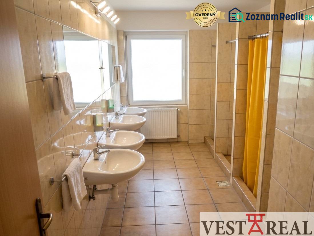 The bathroom in the building offers sinks and showers with a tiled floor.