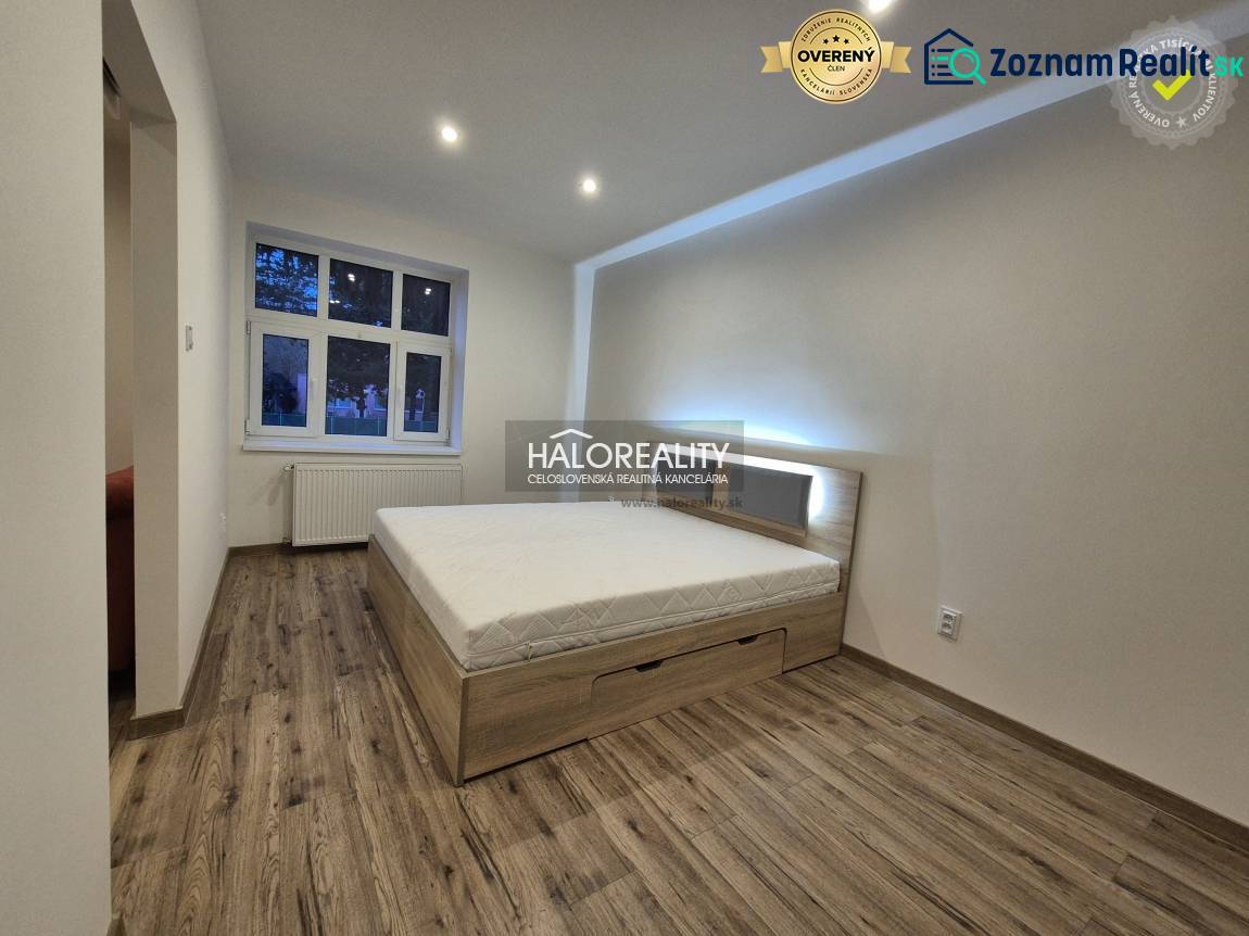 Bedroom in a 2-room apartment with a bed and a wooden decor floor.