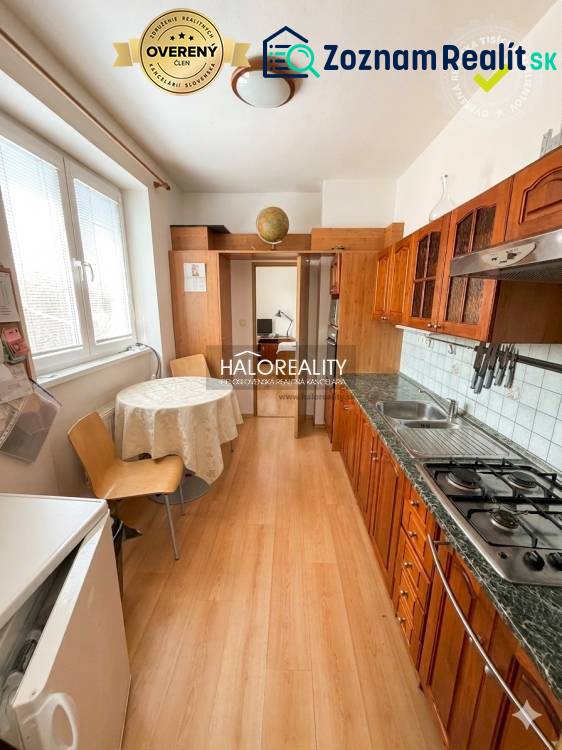 A kitchen in a 3-room apartment with a wooden decor floor and a dining table.