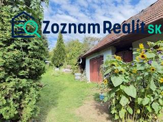 A family house in Krivosúd-Bodovka with red doors and sunflowers in the garden.