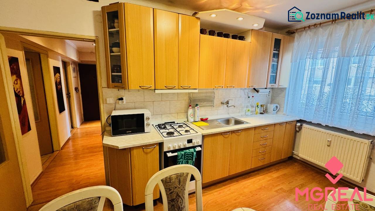 A kitchen in a 3-room apartment with a wooden decor countertop and flooring.