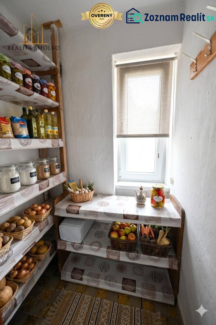 Pantry with shelves, fruits, vegetables, and groceries in a 2-room apartment, light coming through the window.