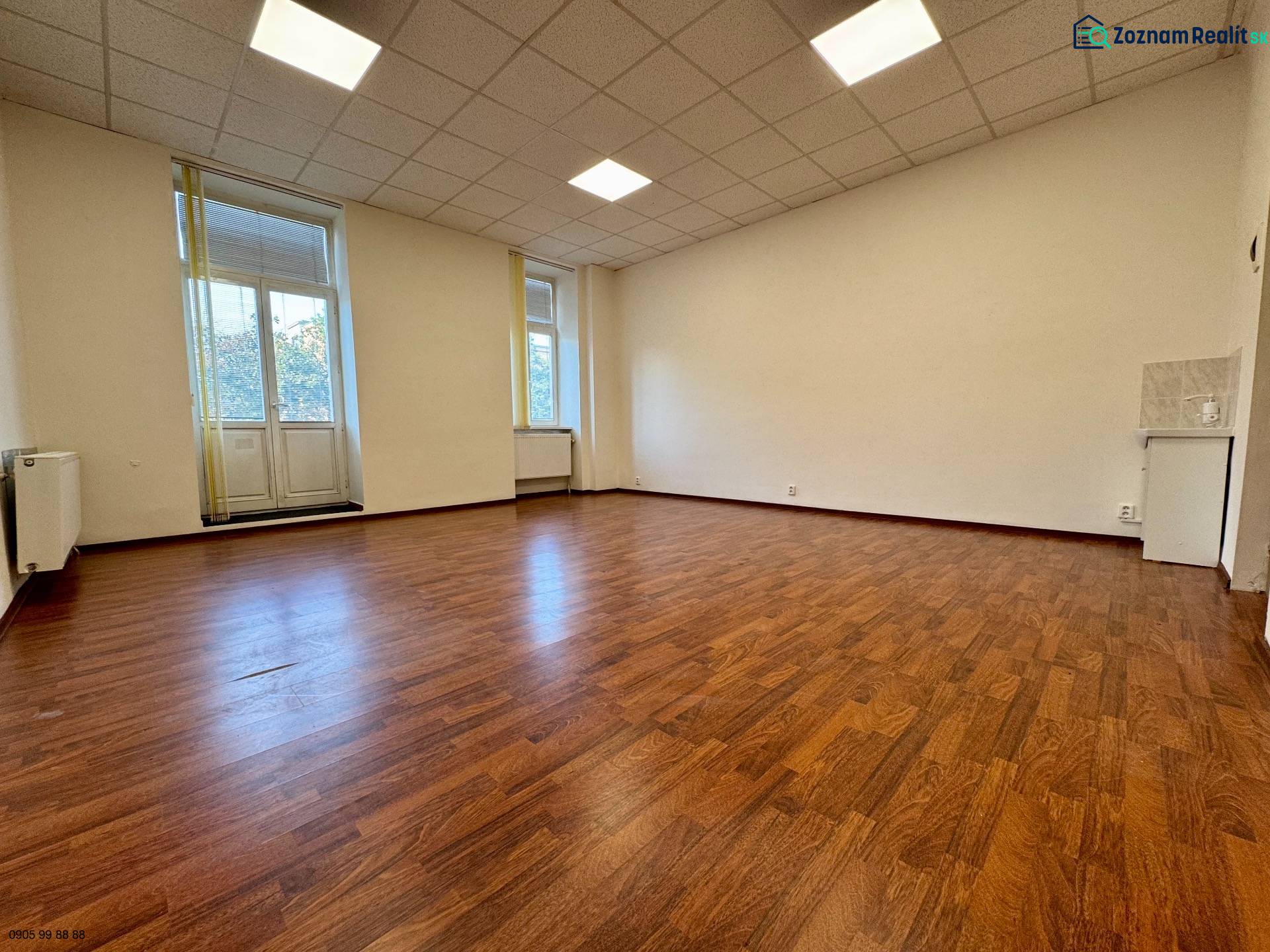 Spacious offices with wood-decor flooring and large windows.